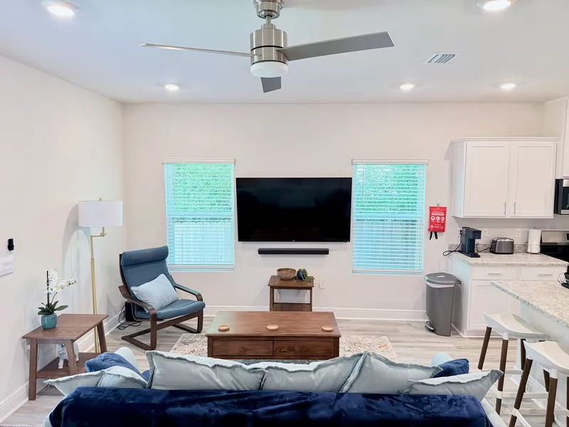 Dining table seating four beside the open living room of the furnished Pensacola rental