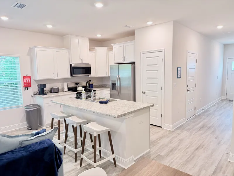 Fully equipped kitchen with stainless steel appliances and breakfast bar seating