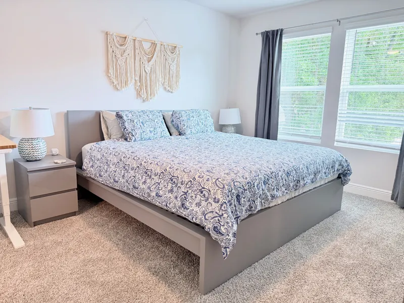 King primary suite with blackout blinds and ceiling fan for restful sleep