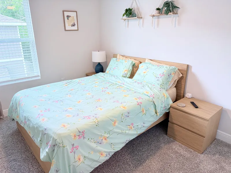 Second bedroom with queen bed and wall-mounted TV